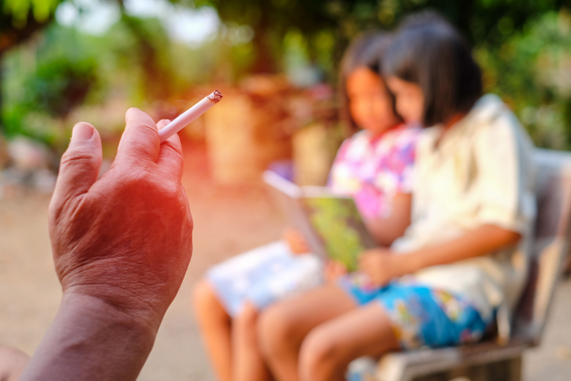 Rokend persoon met kinderen. Foto Shutterstock.