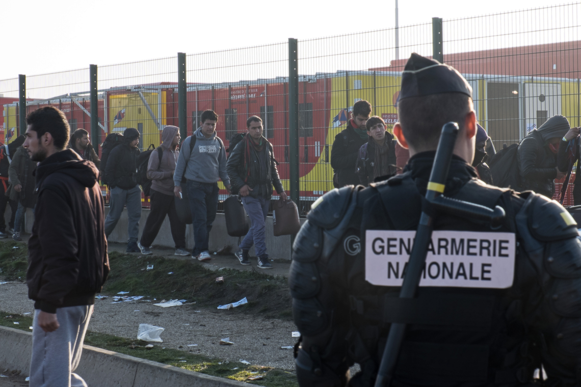 Een Franse gendarme inspecteert een colonne migranten in Calais, archiefbeeld - Afbeelding: Shutterstock