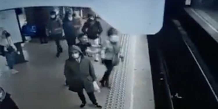 Het moment waarop de dader de vrouw op de sporen duwt - Afbeelding: beelden bewakingscamera (Twitter)