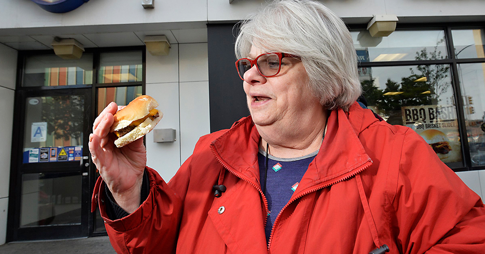 Illustratiebeeld van een vrouw die een veggieburger eet (Photonews)