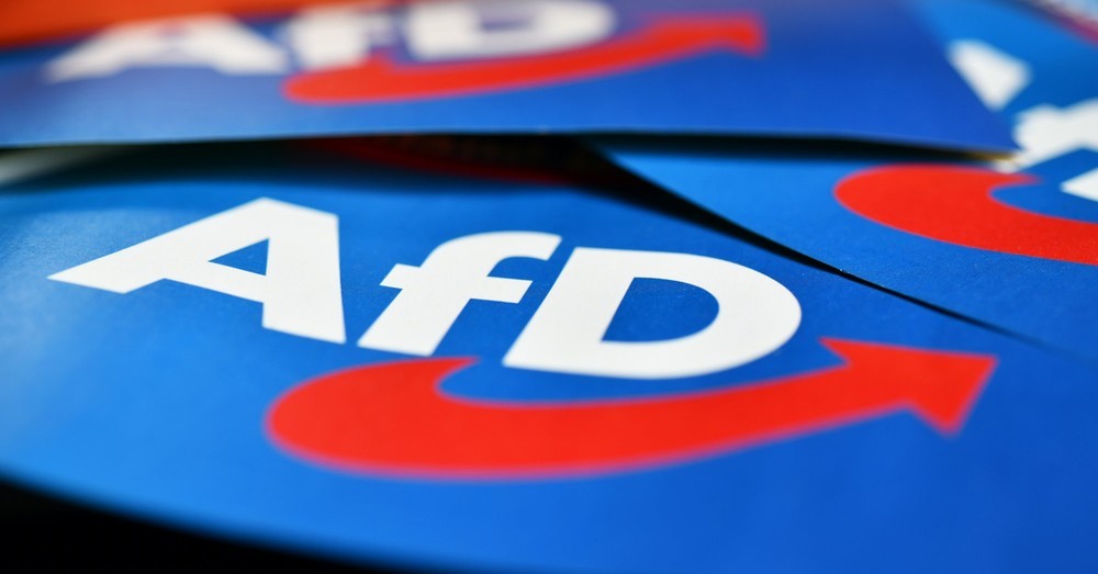Blauwe folders met het witte AfD-logo en rode pijl