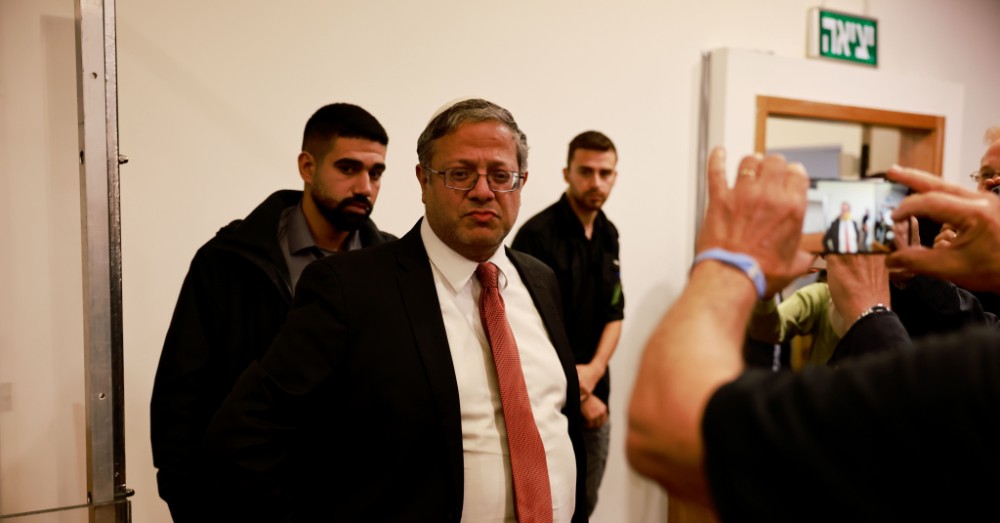 De Israëlische minister Itamar Ben Gvir omringd door medewerkers en fotografen