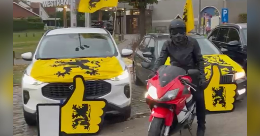 Auto’s met Vlaamse Leeuw-vlaggen en een motorrijder bij de VVB-autokaravaan