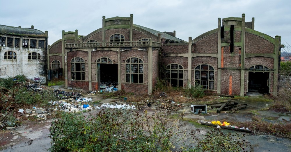 Vervallen bakstenen fabriekshallen met afval op het terrein in Charleroi